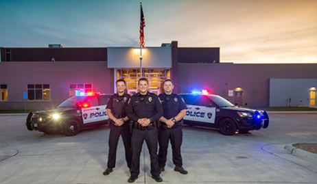 3 officers in front of cars